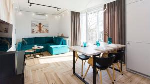 a living room with a table and a blue couch at Apartament 19A - Villa Neptun in Gdańsk