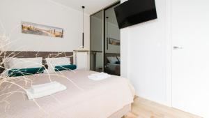 a bedroom with a bed and a flat screen tv at Apartament 19A - Villa Neptun in Gdańsk