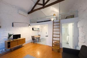 a living room with a staircase and a room with a table at Oporto City View - Trindade in Porto