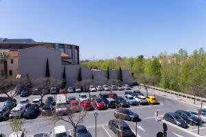 a parking lot with many cars parked in it at Les suites du pont Joffre in Perpignan