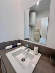 a bathroom with a white sink and a mirror at Les suites du pont Joffre in Perpignan +57 photos
