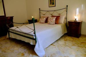 a bedroom with a large bed with two night stands and two lamps at Antonella's house in Casteldaccia