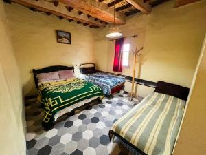 a bedroom with two beds and a window at Riad Bouchra in Tinerhir