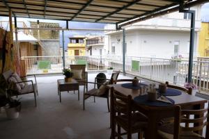 a patio with tables and chairs on a balcony at Antonella's house in Casteldaccia