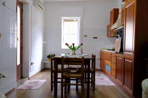 a kitchen with a table and chairs in a room at Antonella's house in Casteldaccia