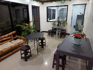 a living room with tables and chairs and a couch at Tiza Manor Inn in Roxas City