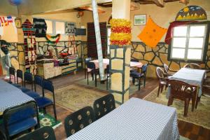 a dining room with tables and chairs and a wall with graffiti at Riad Bouchra in Tinerhir