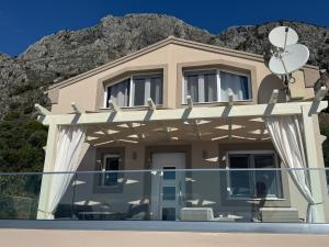 a house in front of a mountain at Vladimiros Apartments in Barbati