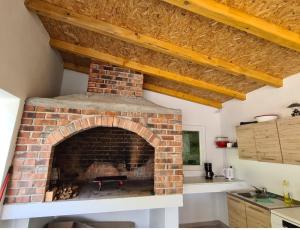 a brick fireplace in the kitchen of a house at Apartman Sunce in Jerkovići