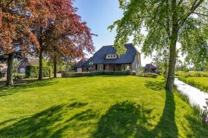 a large yard with a house and trees at It Jachtfjild in Het Jachtveld