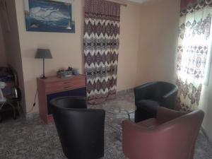 a living room with two chairs and a table at Sunshine Guesthouse Bafuloto in Bafuloto