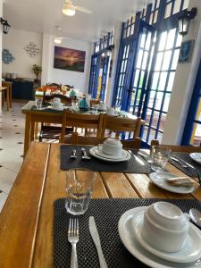 a dining room with a table with plates and silverware at Pousada Thetis in Arraial do Cabo