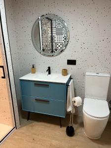 a bathroom with a blue sink and a toilet at La casa de Inocen in Cilleruelo +14 photos