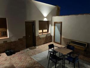 a patio with a table and chairs and a bench at La casa de Inocen in Cilleruelo