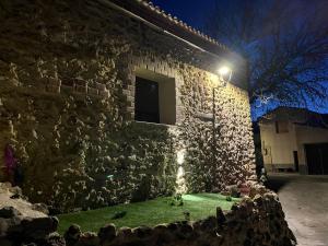 a stone building with a green lawn in front of it at La casa de Inocen in Cilleruelo