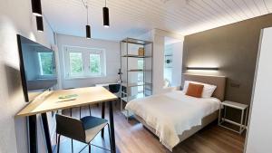 a bedroom with a bed and a desk and a table at Apartmenthouse Viktoria in Bern in Bern