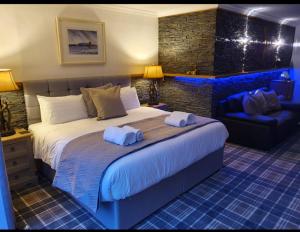 a bedroom with a large bed with towels on it at Tower Ridge House in Fort William