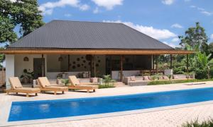 a pavilion with lounge chairs and a pool at Our Stay Mlima in Arusha