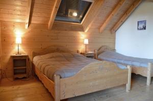 Saint-EustacheにあるGîtes Les Praletsの丸太小屋のベッドが2つある寝室