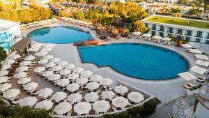 an overhead view of a pool with umbrellas and chairs at Chamada Prestige Hotel and Casino in Kyrenia