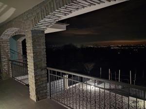 a balcony with a view of the city at night at Casa Piutin, appartamento Bucaneve in Bagnolo Piemonte +2 photos