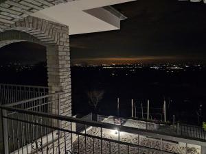 a balcony with a view of a city at night at Casa Piutin, appartamento Bucaneve in Bagnolo Piemonte