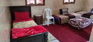 a room with three beds and a chair in it at Airport Agadir Guest House in Agadir