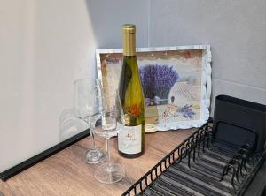 a bottle of wine and two glasses on a table at Apartman Filip in Paraćin