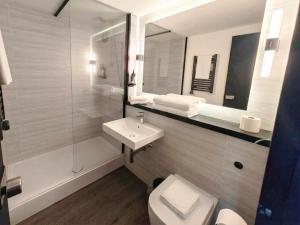 a bathroom with a sink and a toilet and a mirror at The Crossway Hotel, Coventry Walsgrave, Part of AG Collection in Coventry