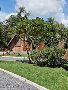 a house with a tree in front of a yard at Tekoha Eco Hotel in Bonito