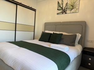 a bedroom with a large white bed with green pillows at Nessie Homes in Nairobi +33 photos