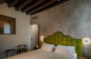 a bedroom with a bed with a green headboard at Ai Due Fanali in Venice