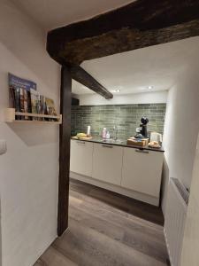 a kitchen with white cabinets and a brick wall at Der kleine Eifel-Ritter in Manderscheid +37 photos