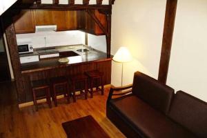 a living room with a couch and a kitchen at Apartamentos Villa de Potes in Potes