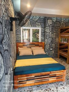 a bed in a room with a stone wall at Farmhouse With Ocean View in Bolinao