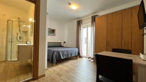 a bedroom with a bed and a bathroom with a shower at Residenza Montegrappa in Peschici