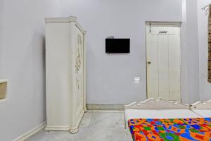 a white room with a bed and a dresser at FabHotel Wellesley in Kolkata