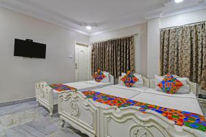 a bedroom with two beds and a flat screen tv at FabHotel Wellesley in Kolkata