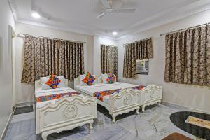two beds in a room with curtains at FabHotel Wellesley in Kolkata