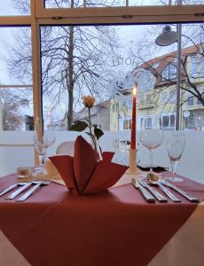 a table with a candle and silverware on a table at Hotel Drei Rosen in Borna