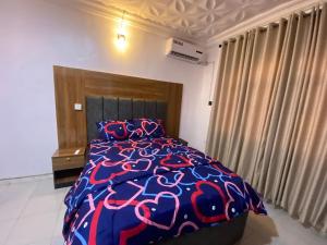a bedroom with a bed with a blue and red comforter at KFP Serene and Modern 2BR Flat , IBD in Ibadan