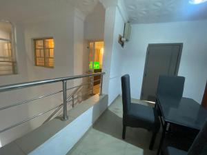 a balcony with a table and chairs in a room at KFP Serene and Modern 2BR Flat , IBD in Ibadan