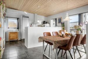 a kitchen and dining room with a table and chairs at LF10202-Thyholm-Markvejen-2 in Thyholm