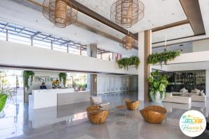 a lobby of a building with wooden furniture and plants at Haven's Villa in Agus