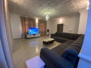 a living room with a couch and a flat screen tv at KFP Serene and Modern 2BR Flat , IBD in Ibadan