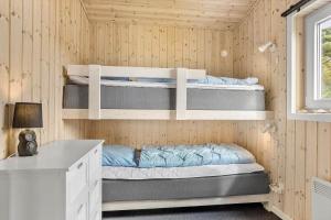 a room with two bunk beds in a wooden wall at LF10202-Thyholm-Markvejen-2 in Thyholm