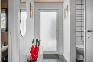 a bathroom with a toilet and red umbrellas at LF10202-Thyholm-Markvejen-2 in Thyholm +16 photos