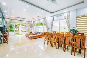 a living room with a dining table and chairs at FLC Sam Son Grand Pool Villa NT48 7BR Near Beach in Sầm Sơn