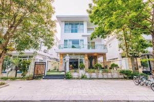 a large white building with a balcony at FLC Sam Son Grand Pool Villa NT48 7BR Near Beach in Sầm Sơn