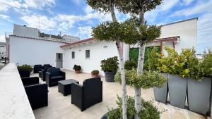 a patio with black chairs and trees and plants at Residenza Montegrappa in Peschici
